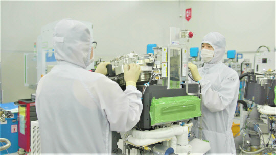 삼성전자 협력회사인 반도체 장비 기업 '원익IPS' 직원들이 반도체 생산설비를 점검하고 있다. <삼성전자 제공>