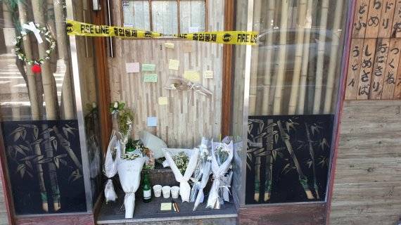 이달 초 코로나19로 인한 경영난을 견디지 못하고 극단적 선택을 한 A씨가 운영했던 마포구 인근 맥줏집 앞에 그를 추모하는 메모지와 국화, 소주병이 놓여 있다. 사진=송주용 기자