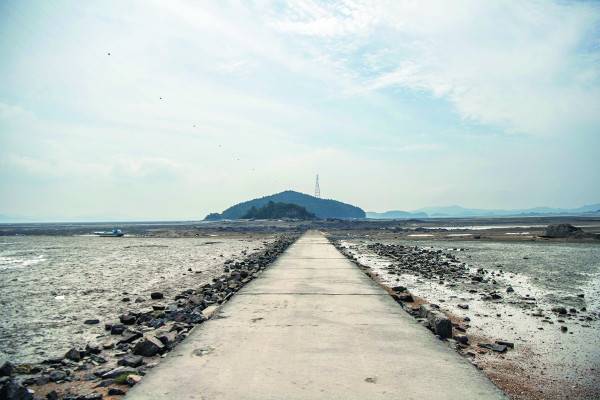 고창개 갯벌 너머로 보이는 솜섬. 뒤쪽 큰 섬은 조도.