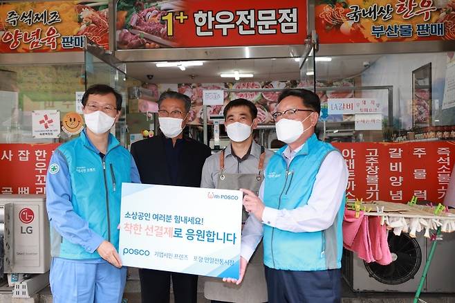 [서울=뉴시스] 포스코 이주태 구매투자본부장(좌측 끝)과 협력기업인 조선내화 이금옥 대표(우측 끝)가 15일 포항 연일시장을 찾아 착한 선결제 행사를 진행하고 상인들과 기념촬영을 하고 있다. (사진=포스코 제공) *재판매 및 DB 금지