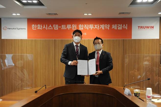 [서울=뉴시스] 어성철한화시스템 대표이사(오른쪽)와 남용현 트루윈 대표(왼쪽)가 체결식 이후 기념촬영을 하고 있다. (사진=한화시스템 제공) *재판매 및 DB 금지