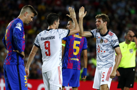 바이에른 뮌헨(독일)의 토마스 뮐러(오른쪽)가 15일(한국시간) 스페인 바르셀로나 캄프 누에서 열린 FC바르셀로나(스페인)와의 2021~22시즌 유럽 챔피언스리그(UCL) 조별리그 1차전 경기에서 후반 11분 쐐기골을 넣은 로베르트 레반도프스키를 축하하고 있다.바르셀로나 AP 연합뉴스