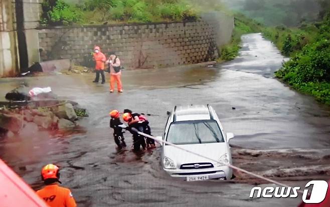 제14호 태풍 '찬투(CHANTHU)'가 제주를 향해 북상 중인 14일 오전 제주시 용강동의 한 도로에 물이 불어나 차량에 고립됐던 한 시민이 신고를 받고 출동한 119구조대에 의해 구조되고 있다.(제주소방서 제공)2021.09.14/뉴스1 © News1 오미란 기자