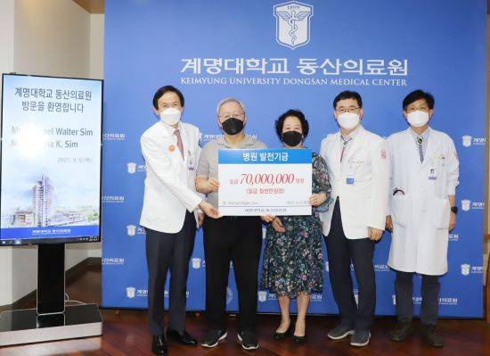 마이클 심 씨 부부가 동산병원에 7000만원을 기탁하고 있다.