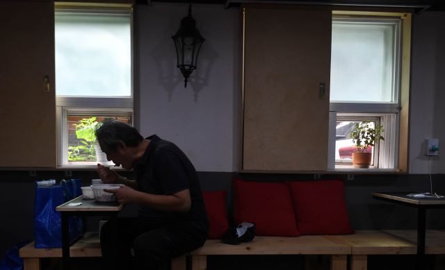 서울 관악구 고시촌에서 혼자 사는 장용기(가명·59)씨가 지난달 26일 민간 무료급식 지원단체 ‘해피인’에서 받은 김치가지볶음덮밥을 점심으로 먹고 있다. 윤성호 기자
