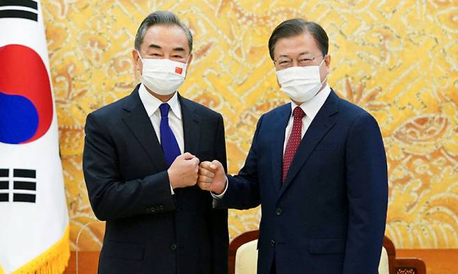 문재인 대통령이 15일 청와대를 예방한 왕이 중국 외교담당 국무위원 겸 외교부장과 주먹인사를 하고 있다. 청와대사진기자단