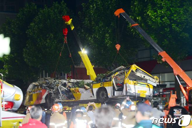 10일 오전 12시30분쯤 광주 동구 학동 재개발지역 건물 붕괴 사고 현장에서 붕괴된 건물에 매몰됐던 45인승 시내버스가 대형 트레일러에 인양되고 있다. 해당 버스는 소속 회사인 대창운수 차고지로 이송될 예정이다.2021.6.10/뉴스1 © News1 정다움 기자