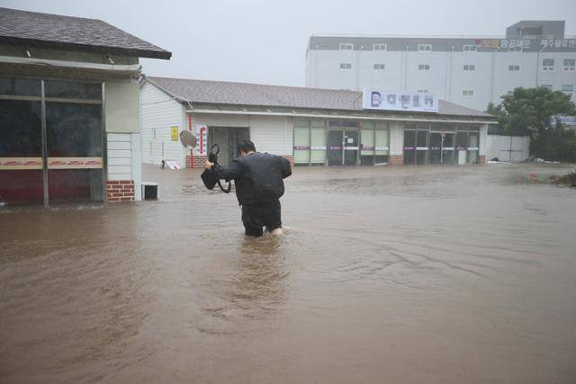 태풍 '찬투'가 제주를 강타한 17일 오전 제주시 용담2동의 저지대 건물이 침수돼 한 주민이 짐을 챙기기 위해 건물로 들어가고 있다.연합뉴스