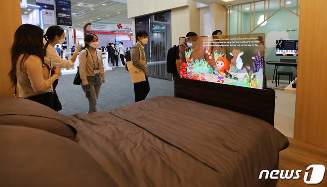 지난 8월25일 서울 코엑스에서 열린 IMID 2021(한국디스플레이산업 전시회)에서 관람객들이 스마트침대에 설치된 LG디스플레이 투명 OLED를 둘러보고 있다. /뉴스1