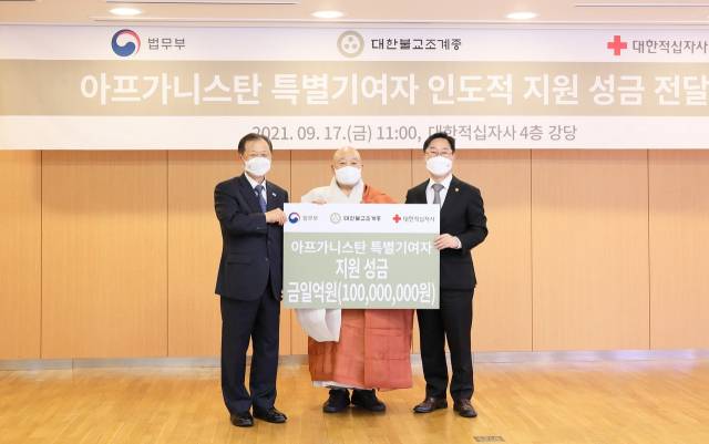 대한불교조계종 총무원장인 원행스님(가운데)이 17일 오전 서울 중구 대한적십자사 서울사무소에서 아프가니스탄 특별 기여자를 위한 기부금 1억 원을 박범계(오른쪽) 법무부 장관과 신희영 대한적십자사 신희영 회장에게 전달한 후 기념촬영을 하고 있다./사진제공=대한적십자사