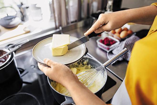 연인 셋을 살해한 혐의로 무기징역을 선고받은 그녀는 진범인가. 주간지 기자 리카는 진실을 캐내기 위해 그녀가 사랑하는 버터 들어간 음식을 먹어보기 시작한다. 사진 속 여성이 버터를 칼로 자르고 있다. /게티이미지코리아