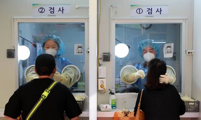 안철수(오른쪽) 국민의당 대표가 18일 오전 서울 중구보건소 선별진료소에서 의료자원 봉사를 하고 있다. 뉴시스