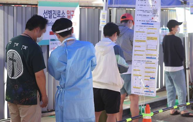 18일 오전 서울 중구보건소 선별진료소를 찾은 시민들이 코로나19 검사를 받기 위해 대기하고 있다. [연합]