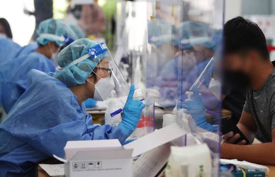 추석 명절 연휴 이틀째인 19일 오전 광주 광산구 선별진료소 의료진이 진단 검사를 하고 있다. 연합뉴스