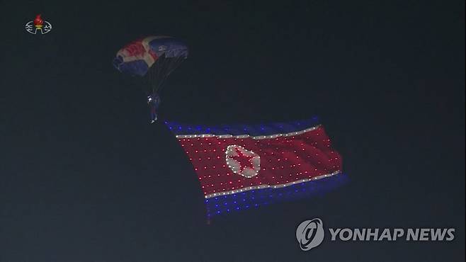 인공기 매달고 내려오는 북한 낙하산병 (서울=연합뉴스) 북한이 정권수립 기념일('9·9절') 73주년인 9일 평양 김일성광장에서 노농적위대·사회안전군의 열병식을 진행했다고 조선중앙TV가 보도했다. 낙하산병이 다리에 커다란 인공기를 달고 열병식 행사장인 광장 위를 활강하고 있다. [조선중앙TV 화면] 2021.9.9 
    [국내에서만 사용가능. 재배포 금지. For Use Only in the Republic of Korea. No Redistribution] nkphoto@yna.co.kr