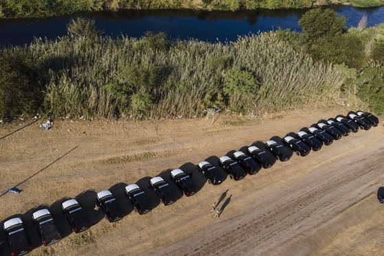 미국 텍사스주 공공안전국 차량들이 22일(현지시간) 멕시코 국경과 맞닿은 리오그란데강 근처에 줄지어 정차해 장벽을 만들었다. [AP=연합뉴스]