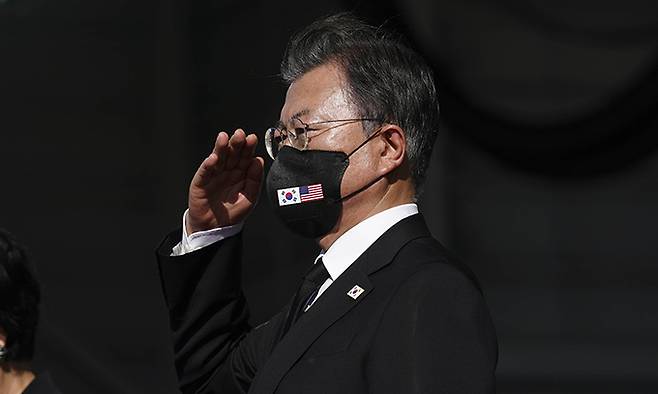 문재인 대통령이 22일(현지시각) 미국 히캄 공군기지 19번 격납고에서 한미 유해 상호 인수식을 마치고 참석자들과 경례하고 있다. 연합뉴스