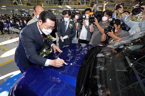 지난 15일 오전 광주 광산구 빛그린산업단지 광주글로벌모터스(GGM)에서 열린 '광주형 일자리' 양산 1호차 생산 기념행사에서 이용섭 광주시장 등 내빈들이 경형SUV '캐스퍼'에 사인하고 있다. 뉴스1