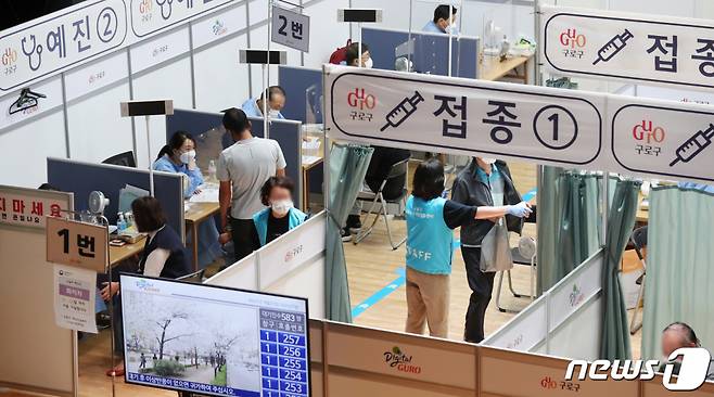 (서울=뉴스1) 민경석 기자 = 23일 오전 서울 구로구 구민회관에 마련된 신종 코로나바이러스 감염증(코로나19) 백신 예방접종센터에서 시민들을 비롯한 국내 거주 외국인들이 예방접종을 앞두고 문진을 받고 있다.  전국적으로 외국인 노동자들의 집단 감염이 잇따르고 있다. 정부는 코로나19 백신을 통한 외국인 노동자 집단감염 차단을 위해 20명 이상 사업장에 임시접종센터를 마련하고 5명 이상만 돼도 출장 접종하는 방안 등을 마련할 계획이다. 2021.9.23/뉴스1