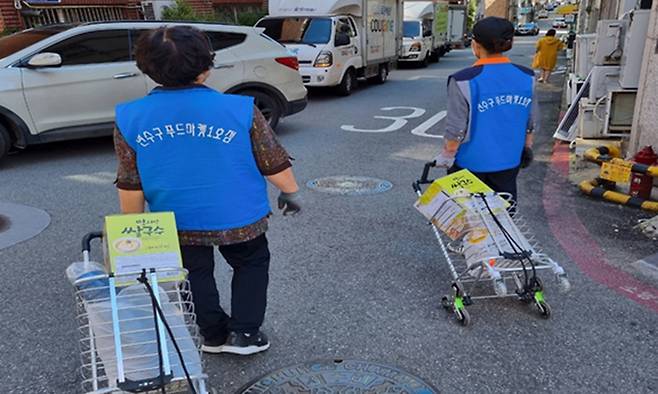 ‘띵동 푸드마켓’ 배송에 참여한 어르신들이 이용자들이 주문한 물품을 옮기고 있다. 인천시 제공