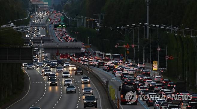 추석 연휴 마지막 날, 해 저문 도로 불 밝히는 차량 행렬 (서울=연합뉴스) 김도훈 기자 = 추석 연휴 마지막 날인 22일 오후 서울 서초구 잠원IC 인근 경부고속도로 상(왼쪽)·하행선 위로 불을 켠 차들이 지나고 있다. 2021.9.22 superdoo82@yna.co.kr