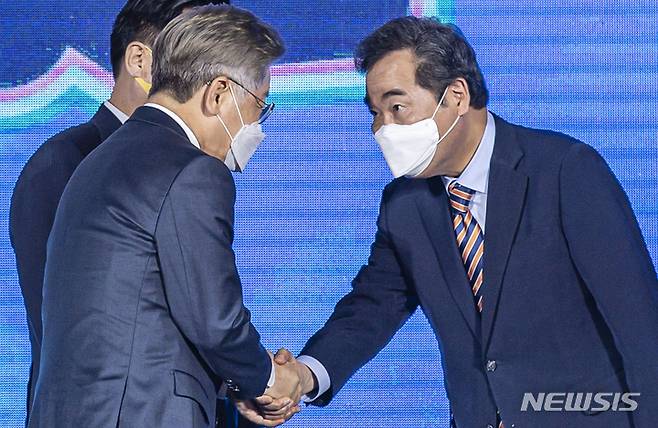 [광주=뉴시스] 류형근 기자 = 더불어민주당 대선 후보 선출을 위한 순회 경선 광주·전남 합동연설회가 25일 오후 광주 서구 김대중컨벤션센터 1층 다목적홀에서 열리고 있다. 투표결과 발표 뒤 이재명·이낙연 후보가 악수를 하고 있다. 2021.09.25. hgryu77@newsis.com