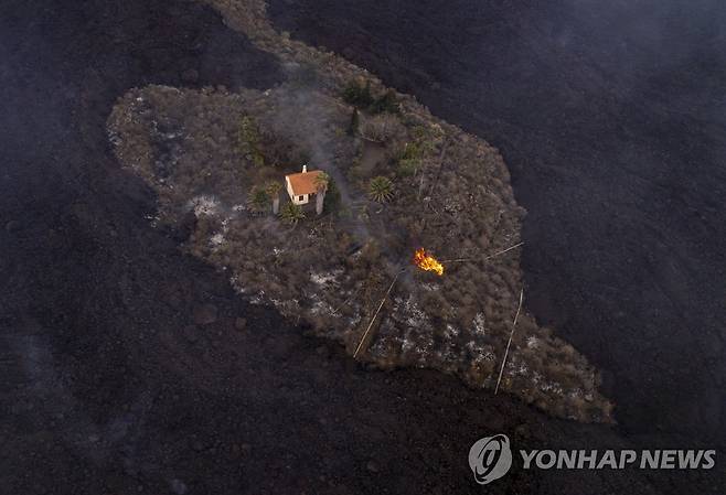 스페인령 카나리아제도 라팔마섬의 화산 폭발로 용암이 사방에 뒤덮인 가운데서도 상태를 보전한 주택의 모습 [iLoveTheWorld 제공·AP=연합뉴스. 재판매 및 DB 금지]