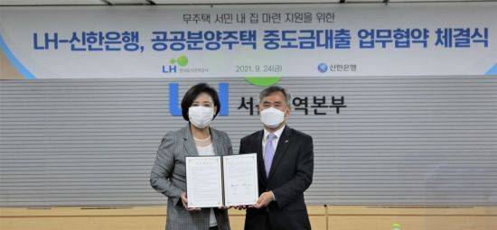 이정관 LH 부사장(오른쪽)과 조경선 신한은행 부행장이 24일 LH서울지역본부에서 공공분양주택 수분양자의 자금부담 완화를 위한 ‘중도금 대출 업무 협약’을 체결하고 기념촬영을 하고 있다. / LH 제공.