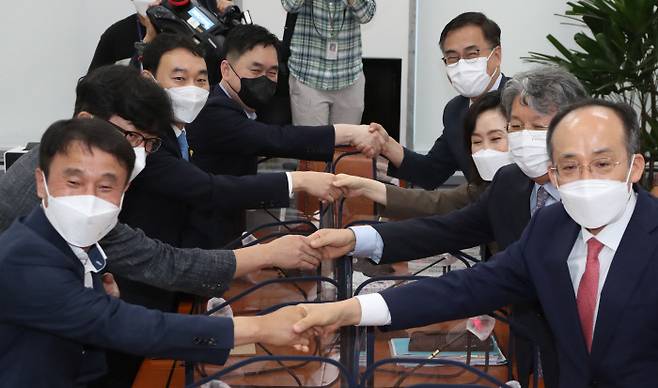 8일 국회 운영위 소회의실에서 열린 ‘언론중재 및 피해구제 등에 관한 법률(언론중재법)’ 개정안 논의 여야 8인 협의체의 상견례 겸 첫 회의에서 참석자들이 악수하고 있다. 왼쪽부터 시계방향으로 더불어민주당 한병도 원내수석부대표, 송현주 한림대교수, 김용민, 김종민 의원, 국민의힘  최형두,전주혜 의원, 문재완 한국외대 법학전문대학원 교수, 추경호 원내수석부대표. 민주당 추천 김필성 변호사와 국민의힘 추천 신희석 법률분석관은 참석하지 않았다. 국회사진기자단