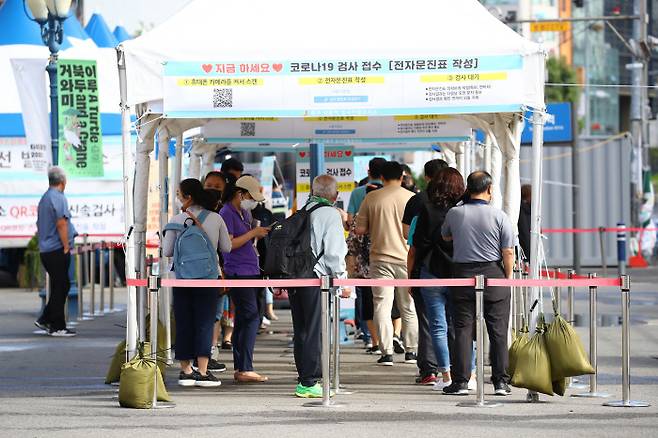 코로나19 누적 확진자 수가 30만명을 넘어선 26일 오전 서울역 광장 앞에 마련된 임시선별검사소를 찾은 시민들이 검체 채취 순서를 기다리고 있다. / 연합뉴스