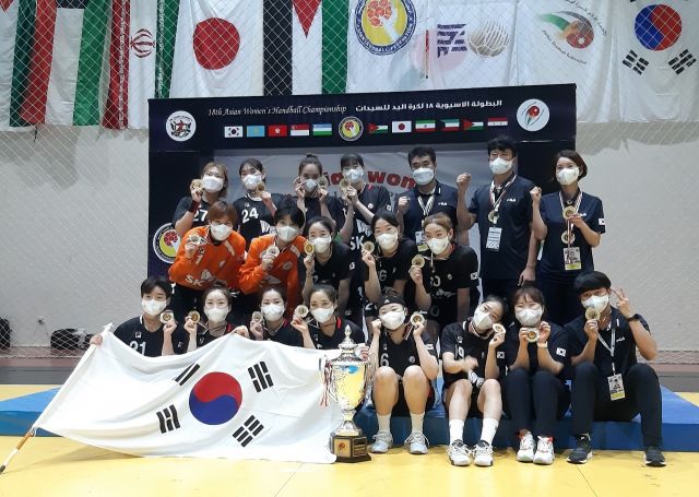 한국 여자핸드볼 대표팀 선수들이 26일(한국시간) 요르단 암만에서 열린 2021 아시아선수권대회 결승전에서 일본을 꺾고 우승한 뒤 트로피 앞에서 기념사진을 촬영하고 있다. 연합뉴스