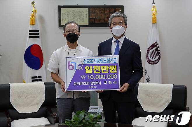 27일 오후 목원대 총장실에서 성천교회 지광식 담임목사(왼쪽)가 권혁대 총장에게 선교조각공원 조성기금 1000만원을 전달하며 기념촬영을 하고 있다.© 뉴스1