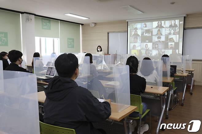 칸막이를 설치한 경일대학교 학생들의 교실.  앞쪽에 비대면 수업을 받는 학생들의 모습이 모니터 화면에 보인다.( 경일대 제공)© 뉴스1