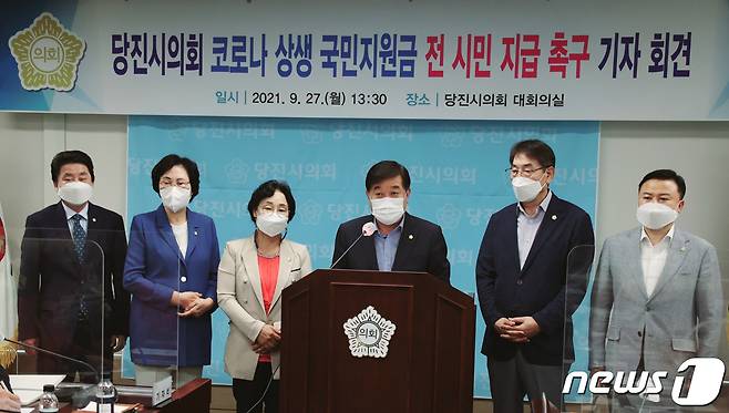 당진시의회(의장 최창용)가 27일 시의회 대회의실에서 전 시민에 대한 코로나19 상생 국민지원금 확대 지급을 촉구하는 기자회견을 하고 있다© 뉴스1