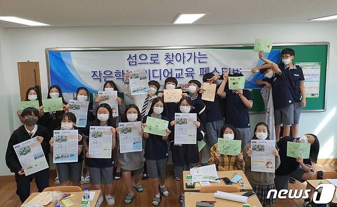 한국언론진흥재단 광주지사의 '섬으로 찾아가는 작은학교 미디어교육 페스티벌'에 참여한 신안 임자중 학생들이 자신의 꿈을 담은 신문을 흔들고 있다.(언론진흥재단 제공)/뉴스1