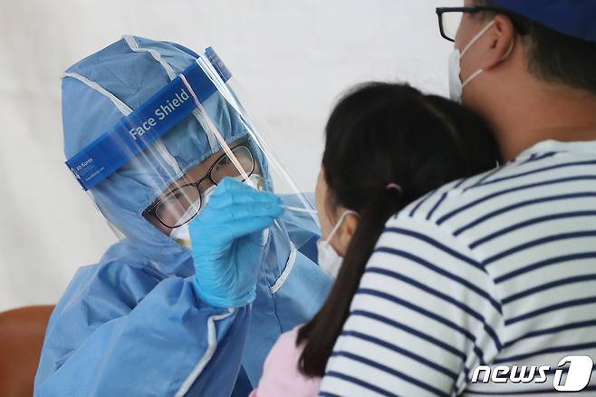 지난 1일 오전 대구 달서구보건소에 마련된 선별진료소에서 의료진이 코로나19 진단검사를 위해 아이의 검체를 채취하고 있다. 2021.9.1/뉴스1 © News1 공정식 기자