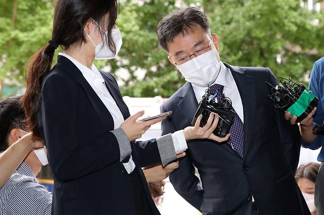 성남 대장동 개발 특혜 의혹이 불거진 화천대유 대주주 김만배 씨가 27일 오전 서울 용산구 용산경찰서에 참고인 신분으로 출석하며 취재진 질문을 듣고 있다./뉴시스