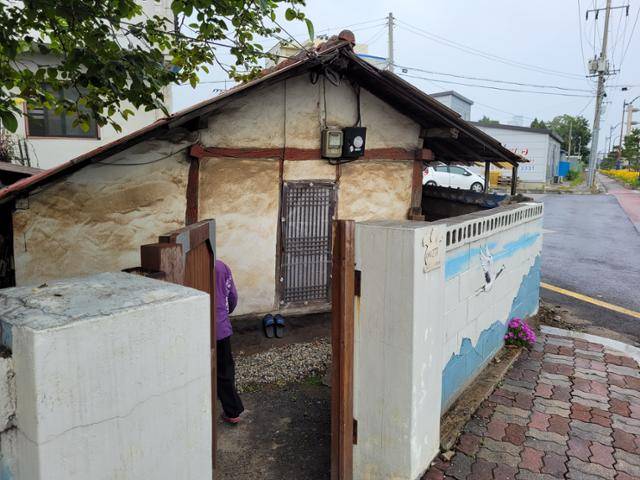 강원 동해 송정동의 주민이 인근 시멘트 공장과 항만에서 날아온 먼지가 벽에 내려앉은 자신의 집으로 들어서고 있다. 송진호 인턴기자