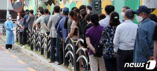 지난 23일 오전 서울 구로구 보건소에 마련된 코로나19 선별진료소에서 시민들을 비롯한 국내 거주 외국인 노동자들이 코로나19 진단 검사를 받기 위해 길게 줄을 서 있다. 사진은 기사 내용과 관련 없음. © News1 민경석 기자