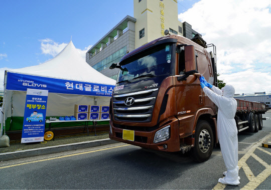 현대글로비스 관계자가 지난 27일 울산화물터미널을 이용하는 화물차 운전자에게 안전용품세트를 전달하고 있는 모습. 현대글로비스 제공