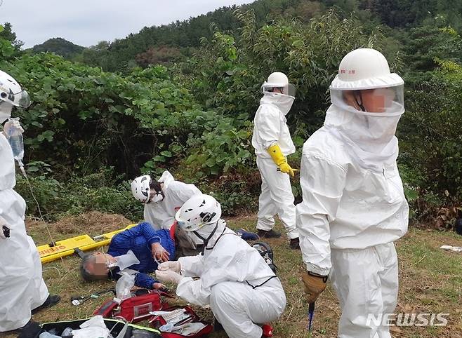 [청주=뉴시스] 안성수 기자 = 28일 오전 충북 옥천군 옥천읍 수북리 인근 야산에서 소방대원들이 벌에 쏘인 환자를 응급처지하고 있다. (사진=충북소방본부 제공) 2021.09.28. photo@newsis.com