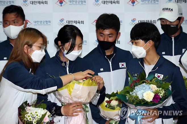 기념촬영에 앞서 (영종도=연합뉴스) 박동주 기자 = 12년 만에 세계선수권대회 전 종목 석권의 위업을 이룬 한국 리커브 양궁의 여자 대표팀 강채영, 장민희, 안산이 28일 오후 인천국제공항을 통해 귀국해 기념촬영에 앞서 꽃을 구경하고 있다. 2021.9.28 pdj6635@yna.co.kr
