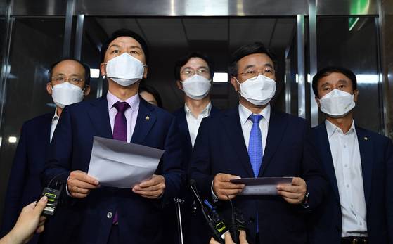 Kim Gi-hyeon, front left, floor leader of the opposition People Power Party, and Yoon Ho-joong, front right, floor leader of the ruling Democratic Party, hold a joint press conference at the National Assembly on Wednesday to announce that they agreed to establish a special committee to discuss a media reform bill. The ruling and opposition leaders announced that the special committee will work on the media revision bill until Dec. 31, 2021, and will consist of 18 members - nine members each from the ruling and opposition parties. [LIM HYUN-DONG]