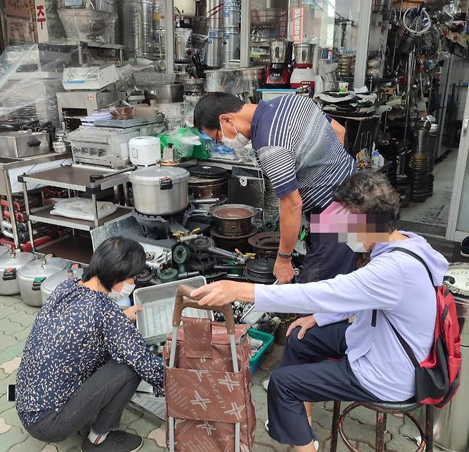 28일 오후 황학동 주방용품거리에서 주방용품가게를 운영하고 있는 신모씨가 '나까마'로부터 철제바구니 4개를 2000원에 구매하고 있다. 철제바구니는 상품가치가 없어 고물상으로 보낼 예정이다. /사진=정세진 기자