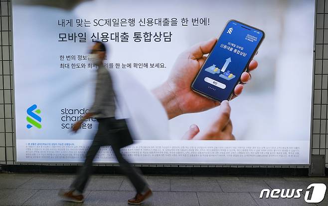 27일 서울시내 지하철역에 걸린 시중은행 대출광고 앞을 시민들이 지나고 있다. 2021.9.27/뉴스1 © News1 안은나 기자