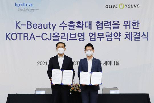 정윤규 CJ올리브영 경영지원담당 상무(오른쪽)와 김상묵 KOTRA 혁신성장본부장(왼쪽)이 기념 촬영을 하고 있다. <CJ올리브영 제공>