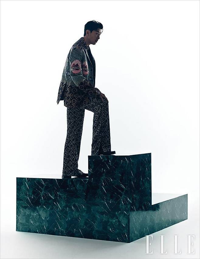 그래픽적 모노그램 패턴의 수트와 셔츠, 로퍼는 모두 Louis Vuitton Men’s Collection.