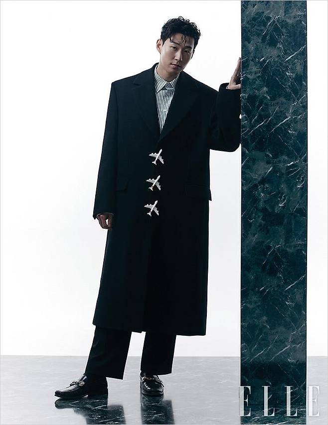 비행기 버튼으로 포인트를 준 롱코트와 스트라이프 셔츠, 팬츠, 로퍼는 모두 Louis Vuitton Men’s Collection.