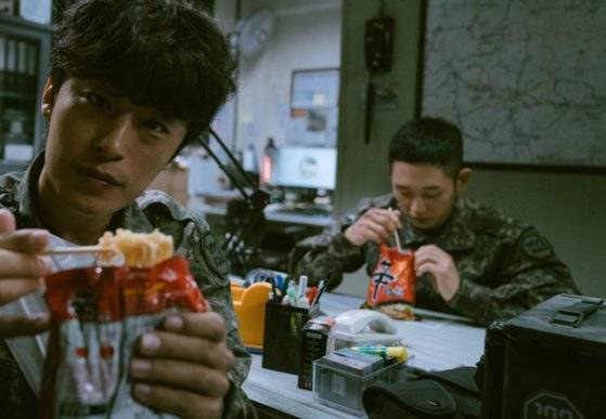 넷플릭스 오리지널 'D.P.'에서 주인공 정해인과 구교환이 라면봉지에 뜨거운 물을 부어 만드는 이른바 '뽀글이라면'을 먹고 있다. [사진 넷플릭스]