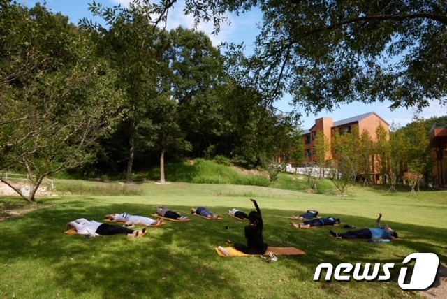 ‘장애인 보호자 숲케어 캠프’ 참가자(보호자)들이 8월 19일 대전 유성구 국립대전숲체원 잔디관장에서 통나무 명상 프로그램에 참가해 휴식 시간을 갖고 있다. (산림청 한국산림복지진흥원 제공) © 뉴스1